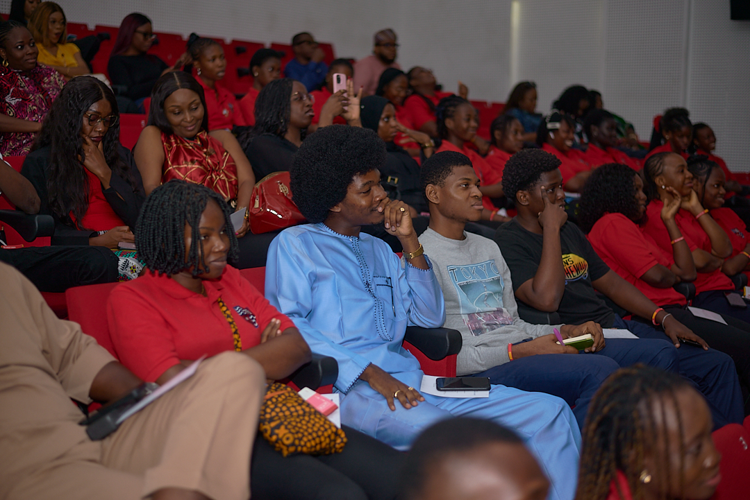 An audience seated in red chairs at an IDAN gathering